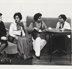 Photo of four individuals sat down on sofas