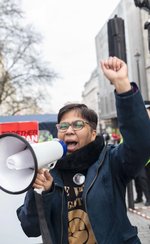 Image of Vandana Aparanti speaking into loudspeaker.
