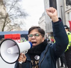 Image of Vandana Aparanti speaking into loudspeaker.
